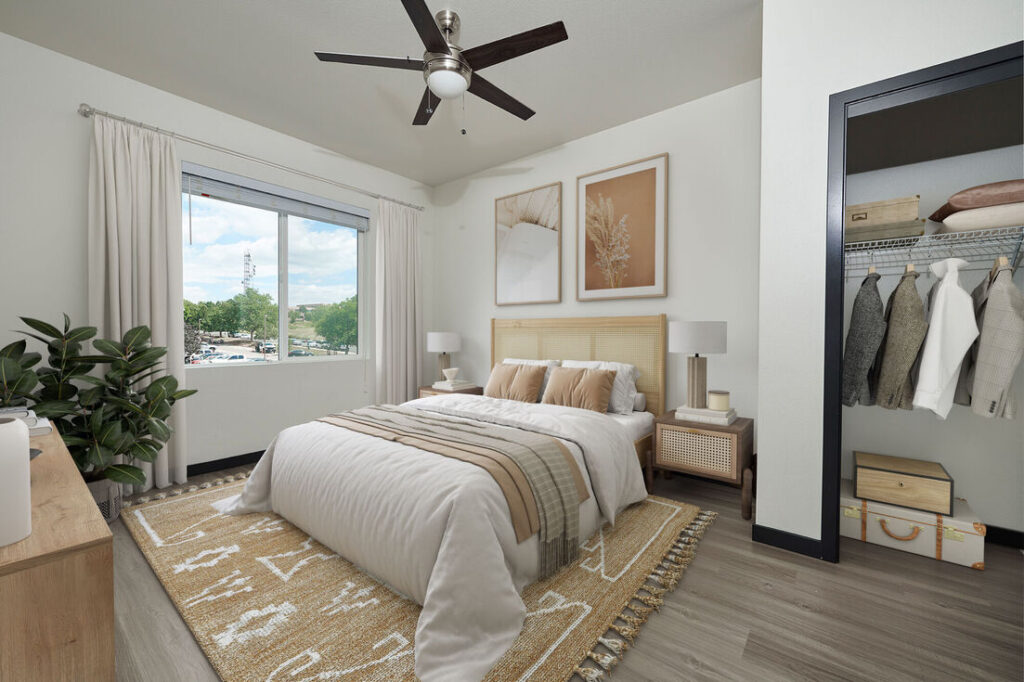Modern bedroom with large window at Westbury Apartments in Westminster, Colorado